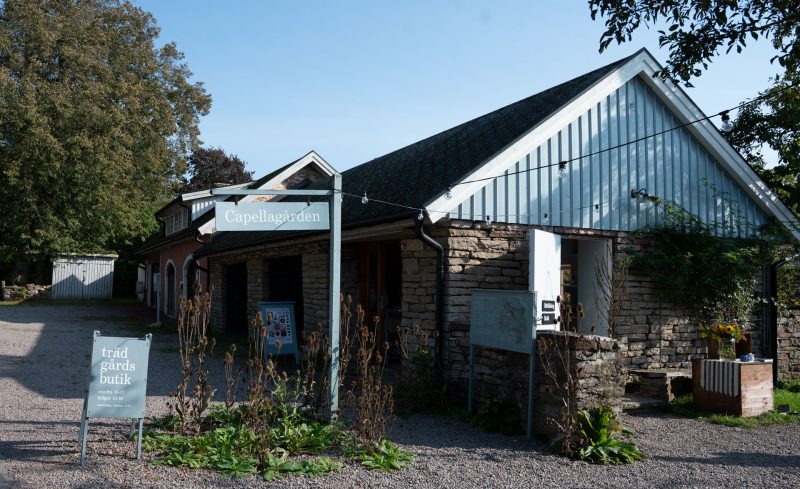 Ett ljusblått hus med väggar i ölandssten. I förgrunden syns en skylt som utläses ''Capellagården''.