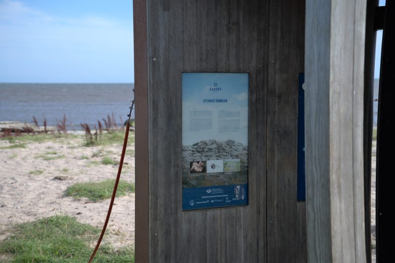 På stranden precis utanför borgmuren står en träbod där det finns information och bilder från utgrävningarna.