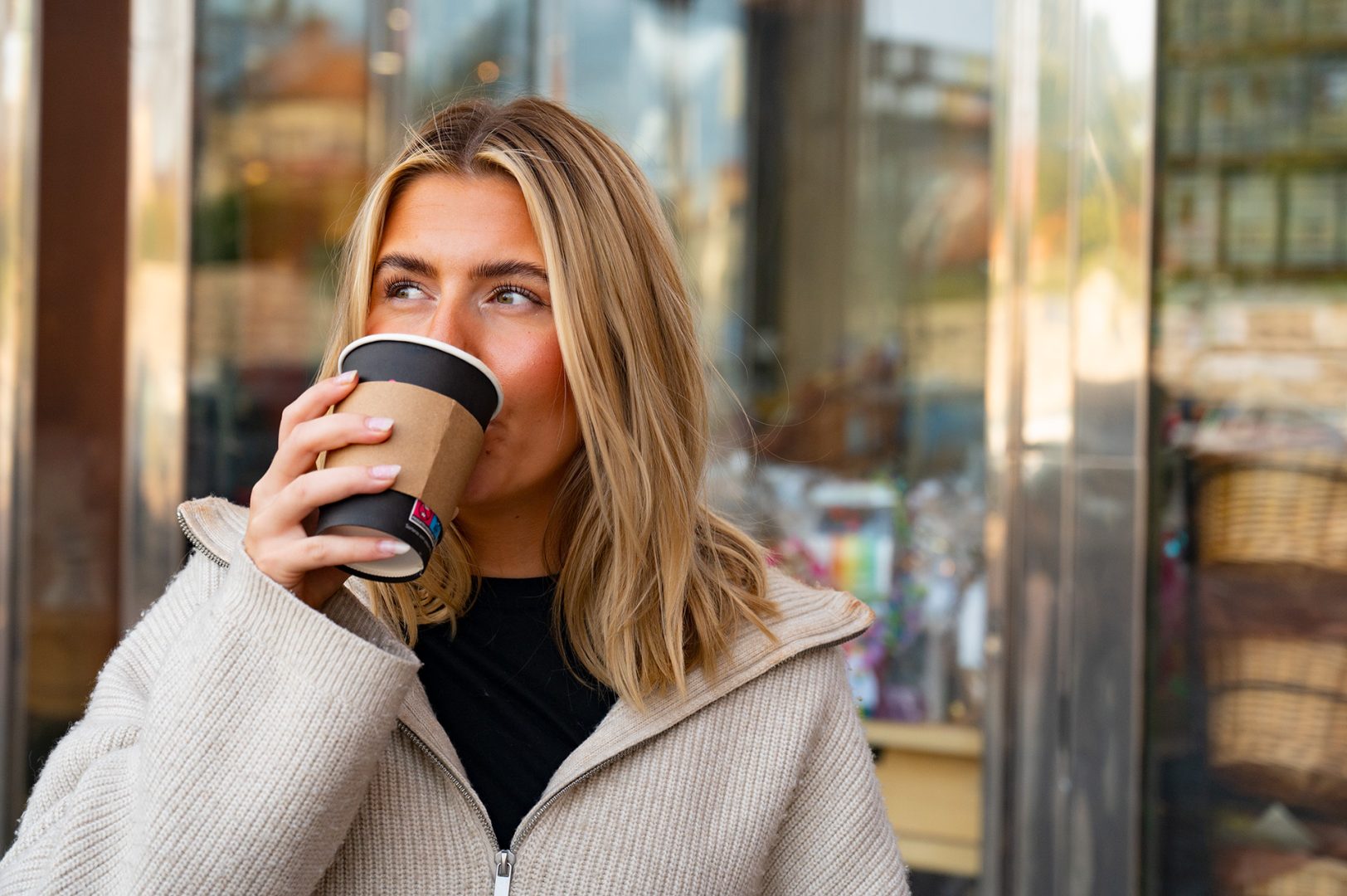 Wilma Broberg dricker kaffet från Kahls och kollar åt sidan.