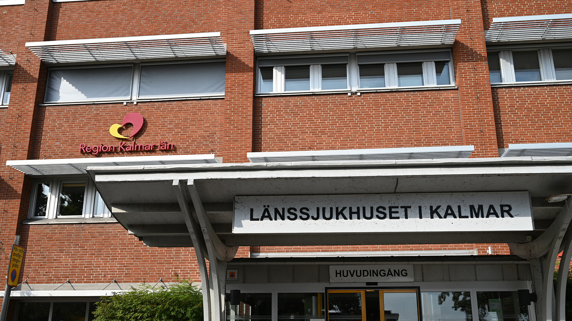 Bild utifrån på huvudingången till länssjukhuset i Kalmar. Region Kalmar läns logga sitter på väggen.