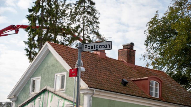 skylt på postgatan. framför ett hus