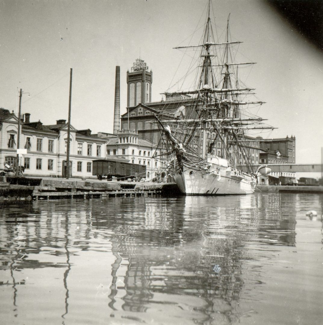 Ett segelfartyg i en hamn med byggnader bakom.