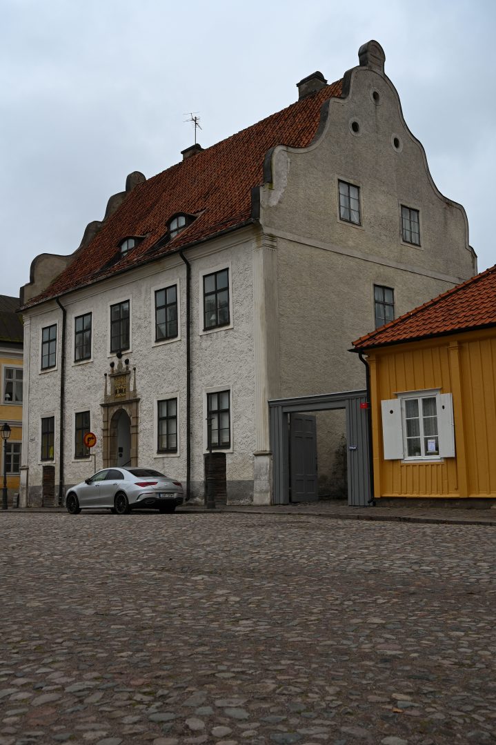Ett hus vid ett torg med en bil parkerad framför.