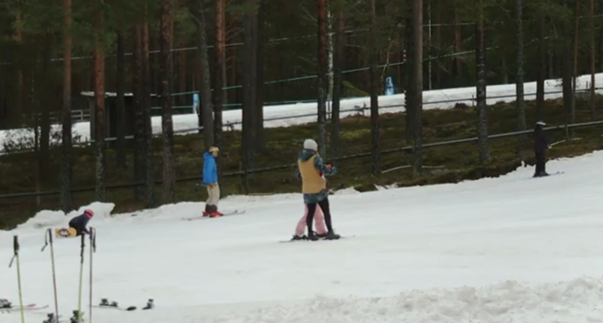 Folk som står i en skidbacke.