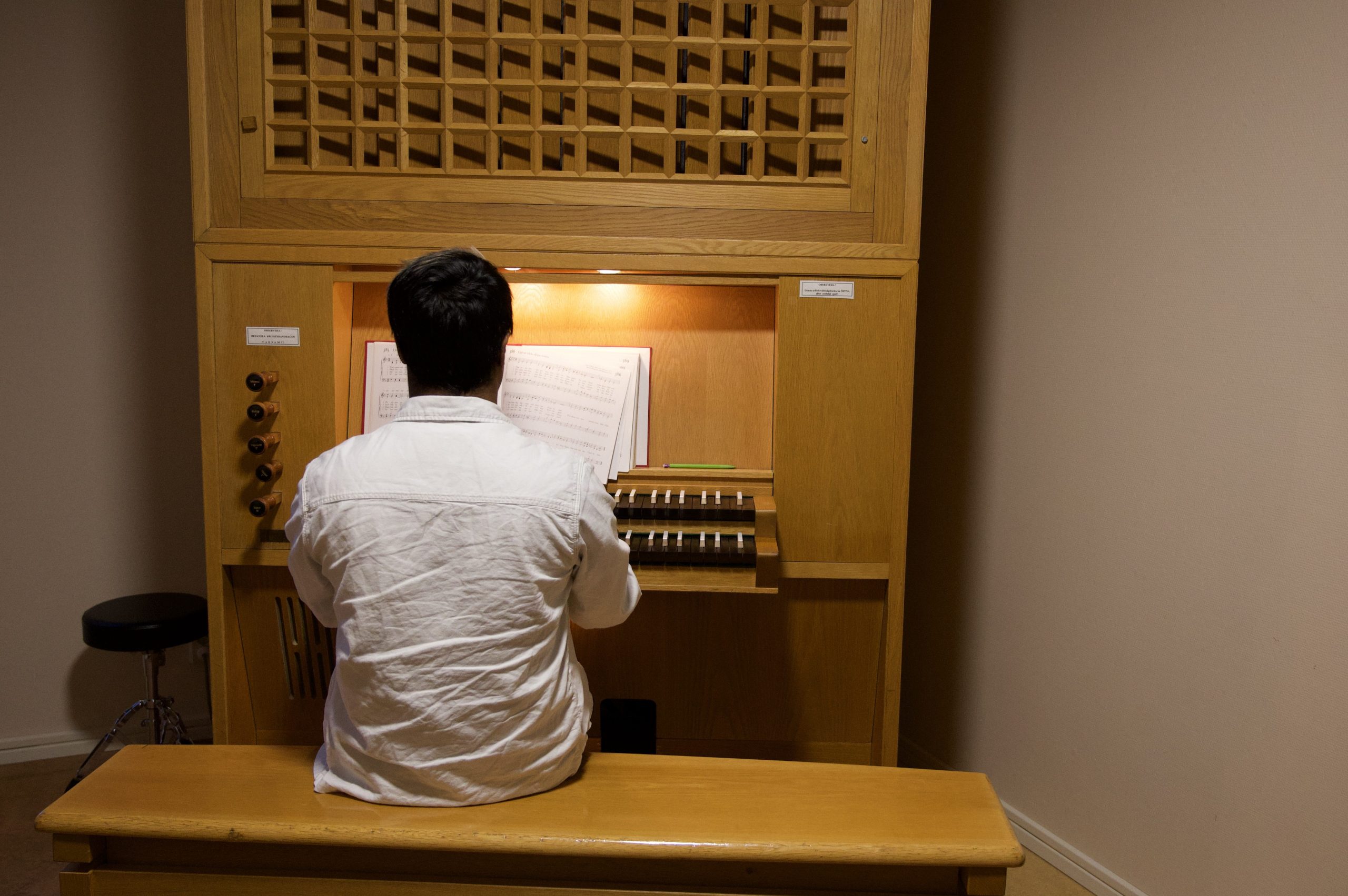 Adam sitter framför en orgel på skolan i Oskarshamn.
