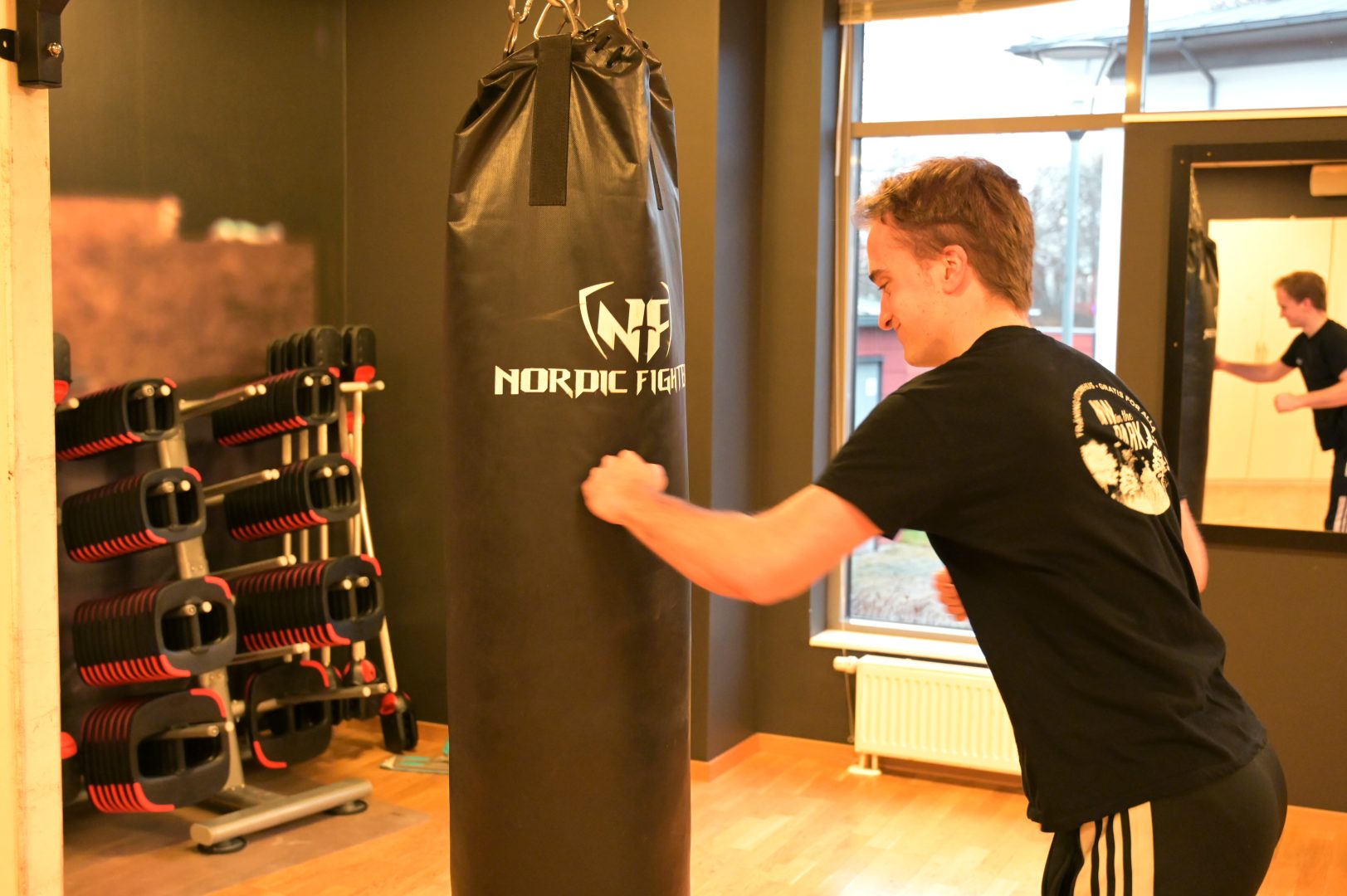 Martin Münch slår på boxningssäcken i gymlokalen.