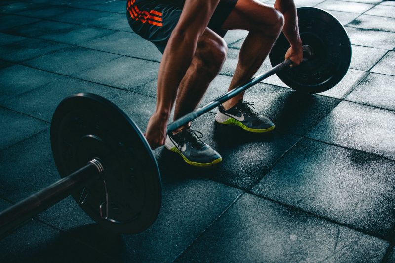 Man lyfter en skivstång på ett gym.