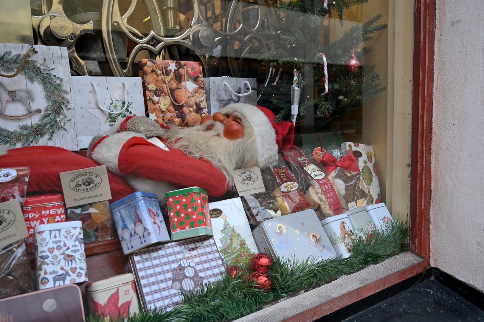 Ett skyltfönster med en tomte och teprodukter runtomkring.