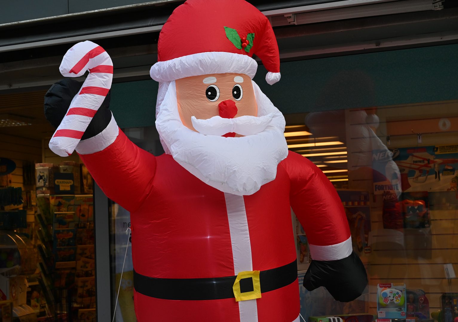En stor uppblåsbar tomte står utanför en butik.