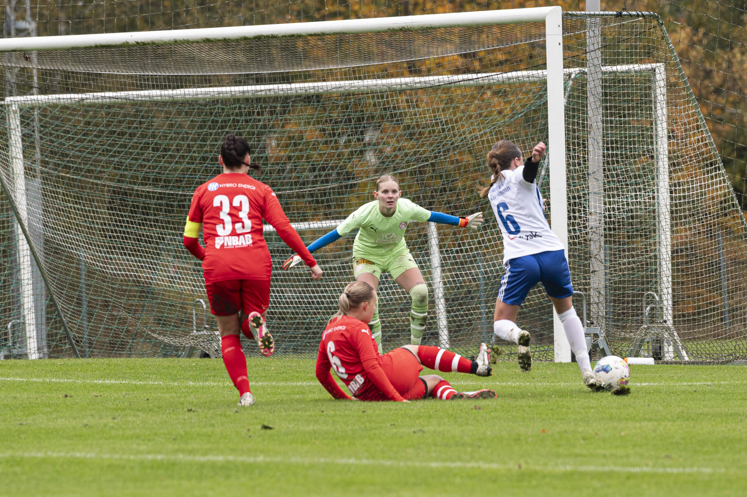 Felicia Engelholm från Medesjö IF stoppar Violetta Burgo från IFK Karlshamns anfall mot målvakten Elin Holmberg från Madesjö IF med en glidtackling. Evelina Eklund från Madesjö IF springer bredvid med nummer 33 på Madesjövallen i Nybro.  Foto: Kajsa Sjöberg.