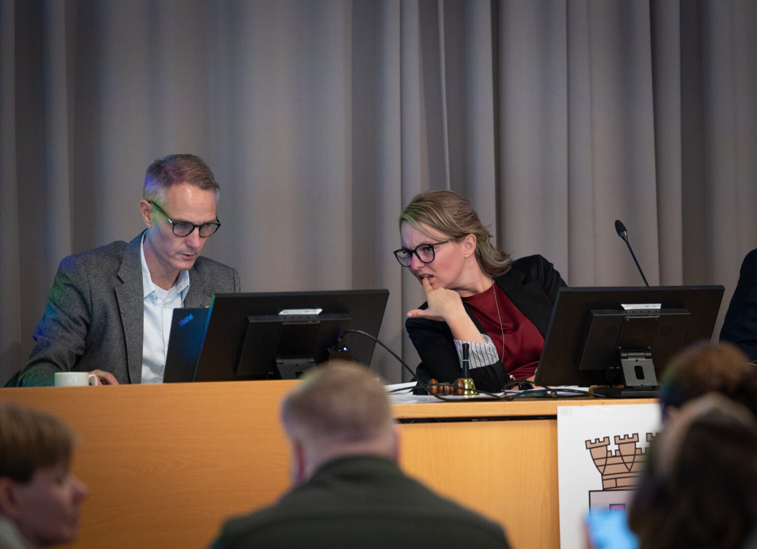 Kalmar kommunfullmäktiges ordförande tittar fundersamt ner på hennes kollegas datorskärm.