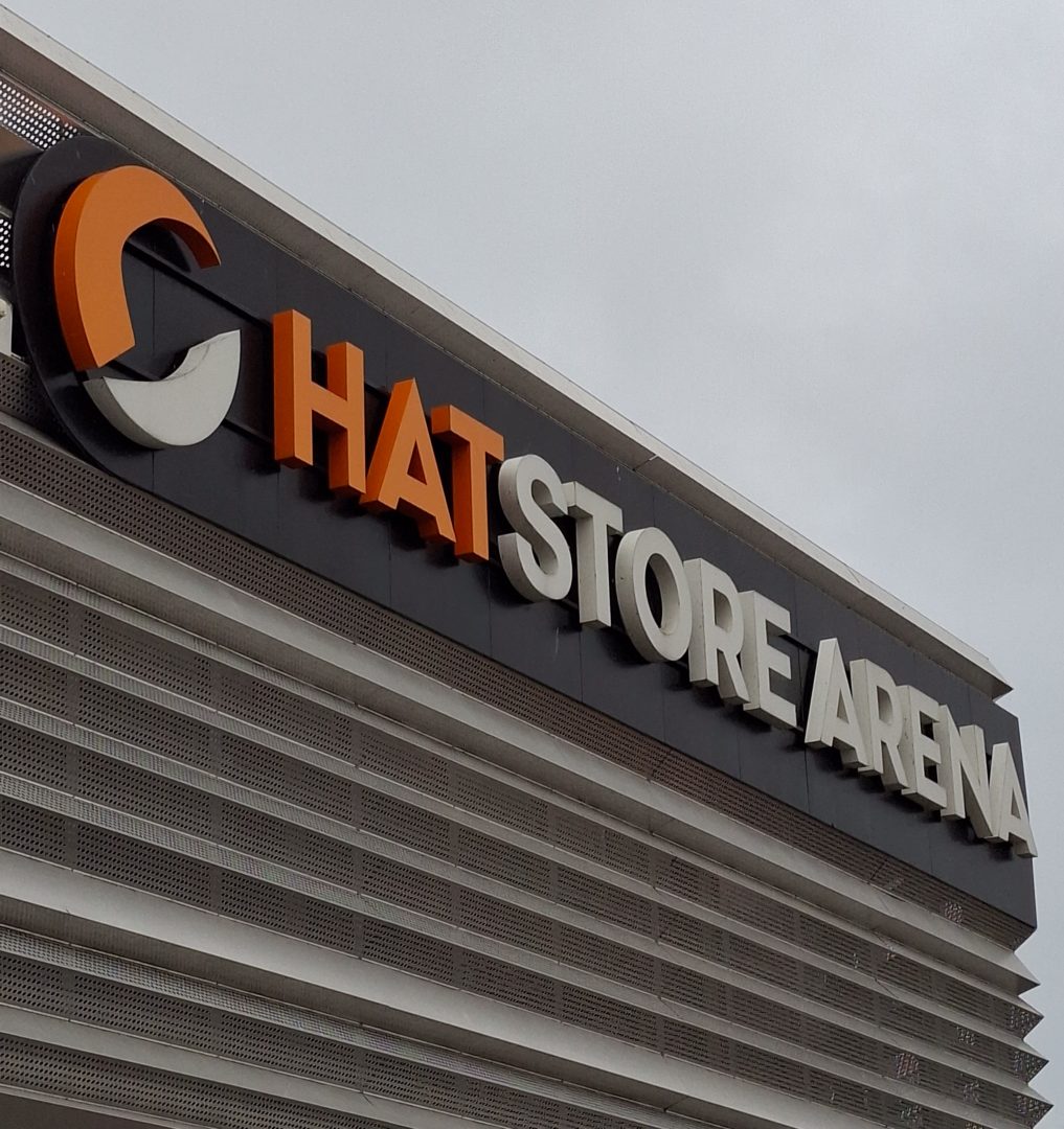 Bild på en skyllt där det står i orggane och vita bokstäver hatstore arena