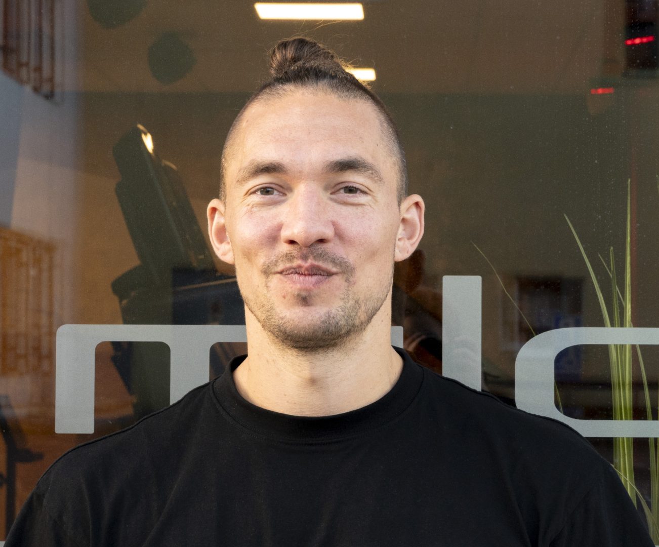 Janne Löfvenberg står framför ett fönster och ler mot kameran 