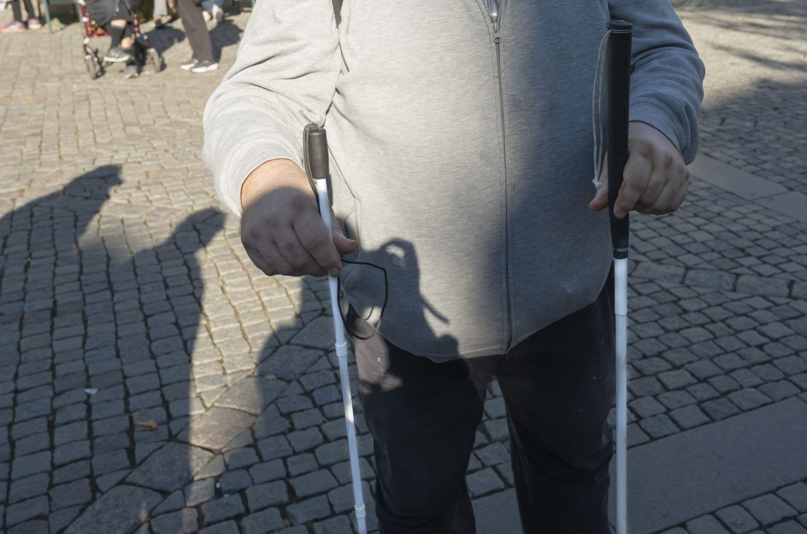 En bild på Magnus Antonsson som visar upp två olika typer av vita käppen.