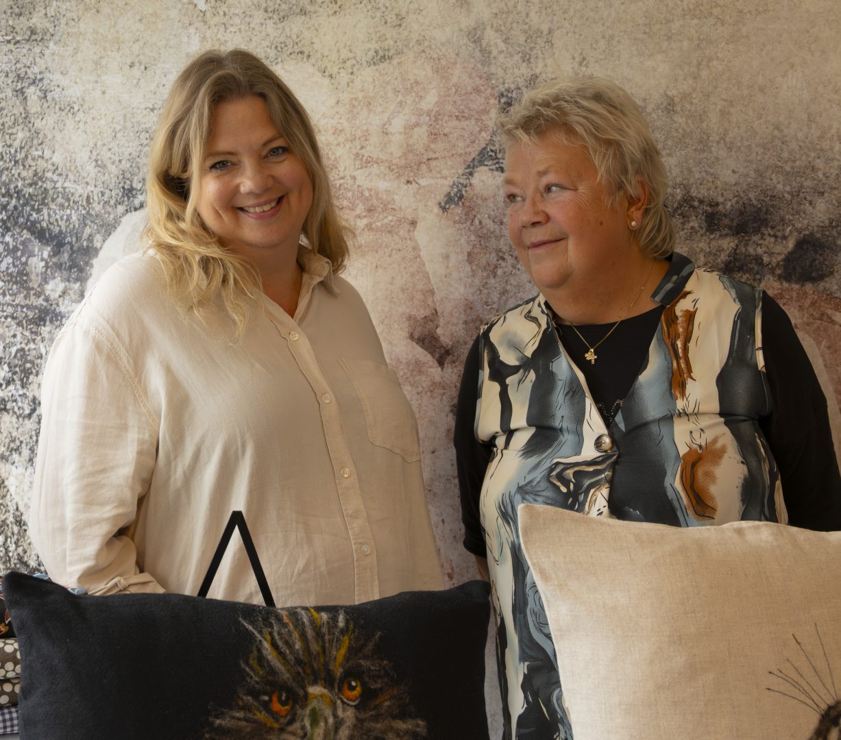 Två kvinnor står framför deras hantverk.