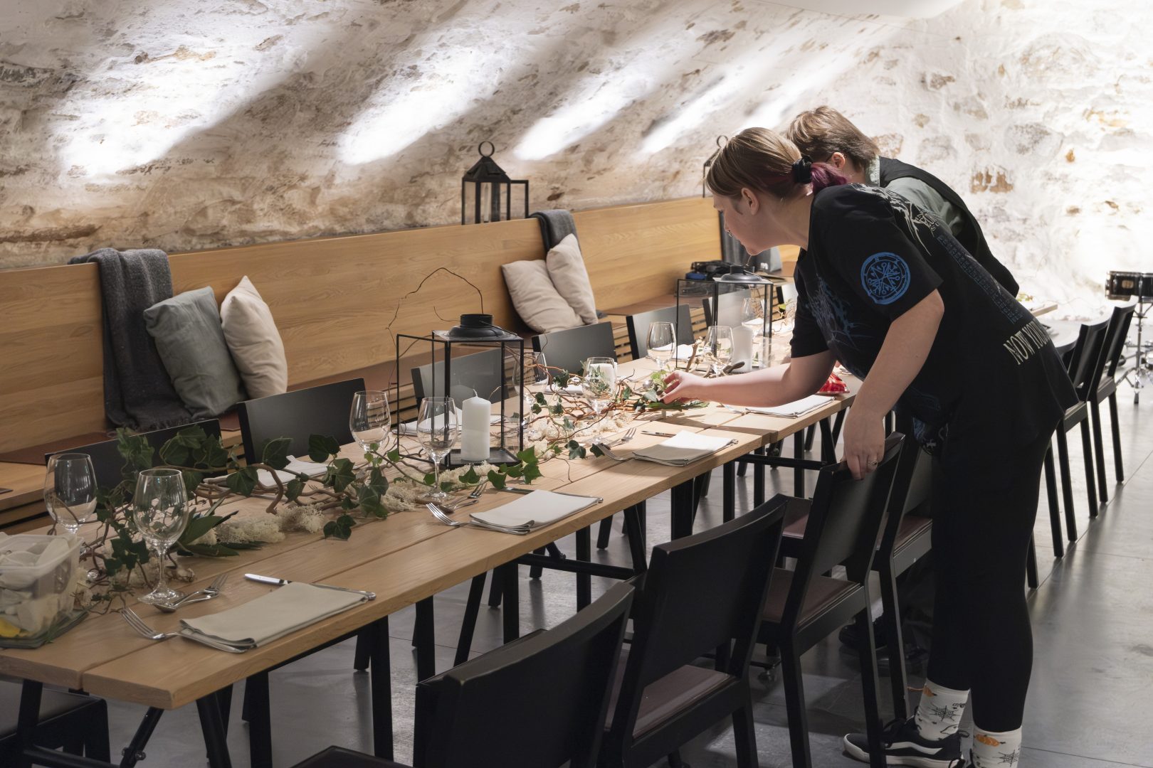 Två personer står och dekorerar ett bord.