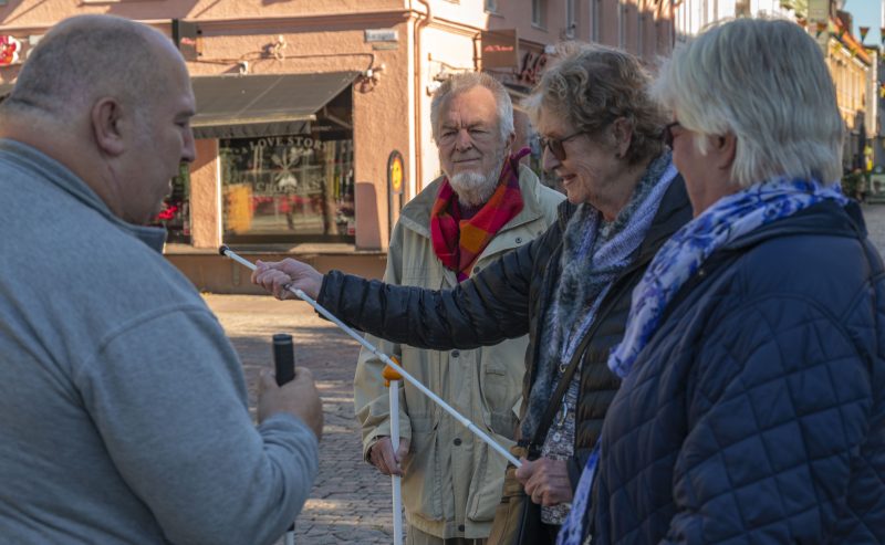 En bild på medlemmar från SRF som står på larmtorget inför träffen på vita käppens dag.