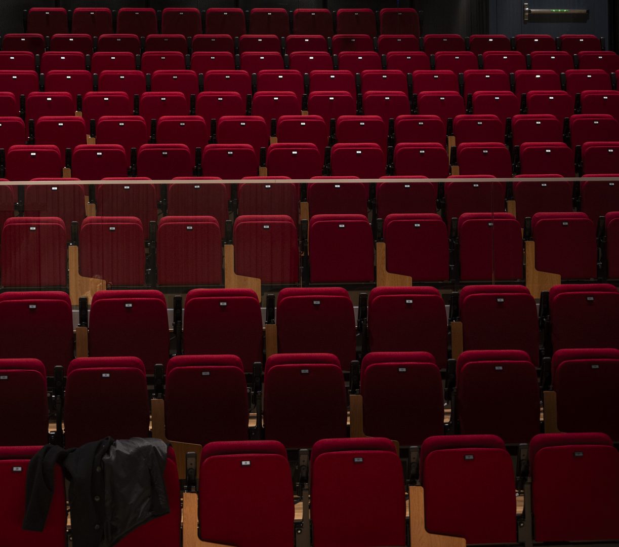 Röda stolar i konserthallen i kulturhuset Strömmen. Sammetsstolarna lyses upp från lampor i taket.