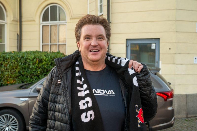 Glad kille håller upp sin Nybro Vikingshalsduk.