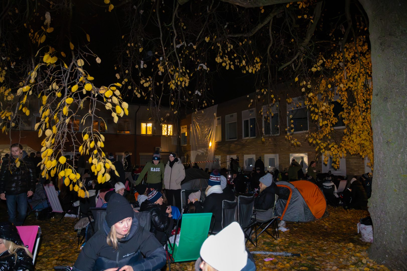 En stor folkmassa sitter utomhus och köar för att få biljetter till rugbymatchen.