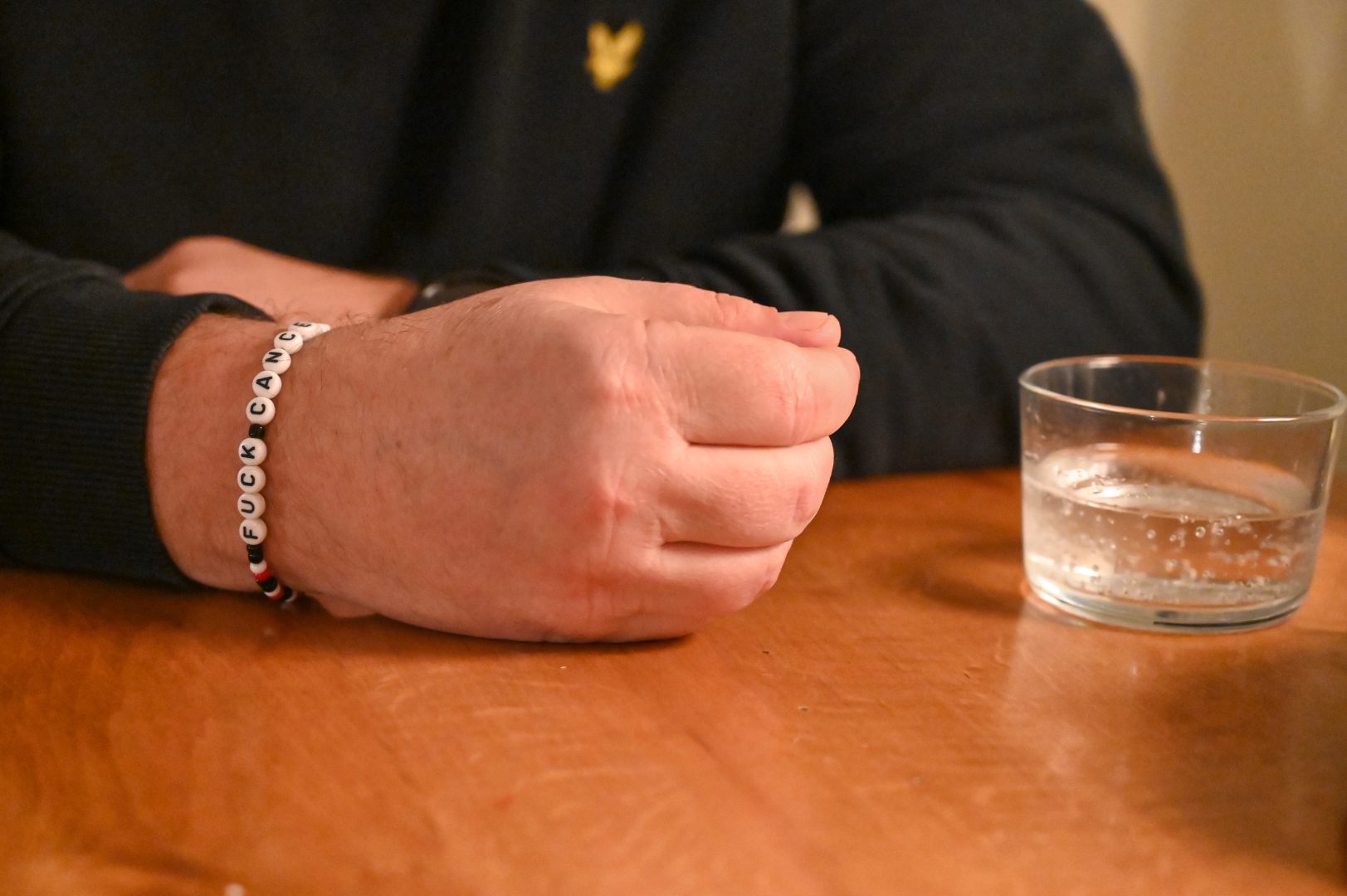 Sam Cansunds hand med ett armband med texten "Fuck Cancer"