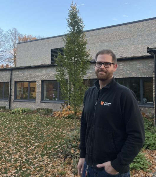 Kyrkogårdschefen står med blicken riktad mot kameran och ler.