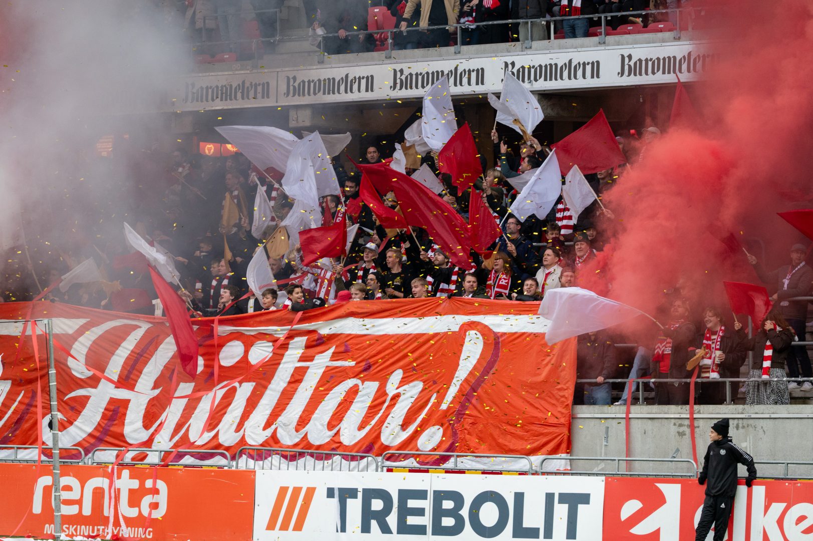 Engagerade supportrar fyller läktaren med rödvitt hav av flaggor och rök när laget går in på planen.