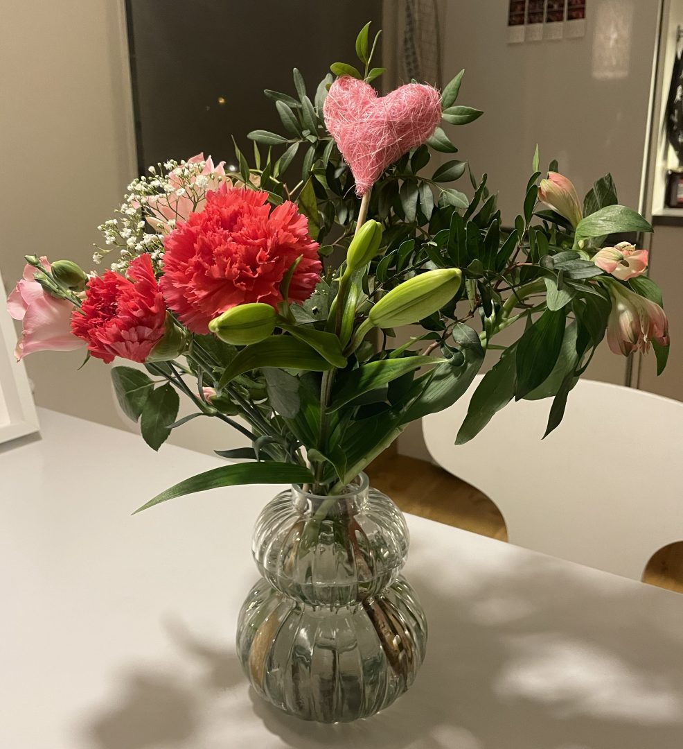 En bucket med blommor i en vas på ett bord.