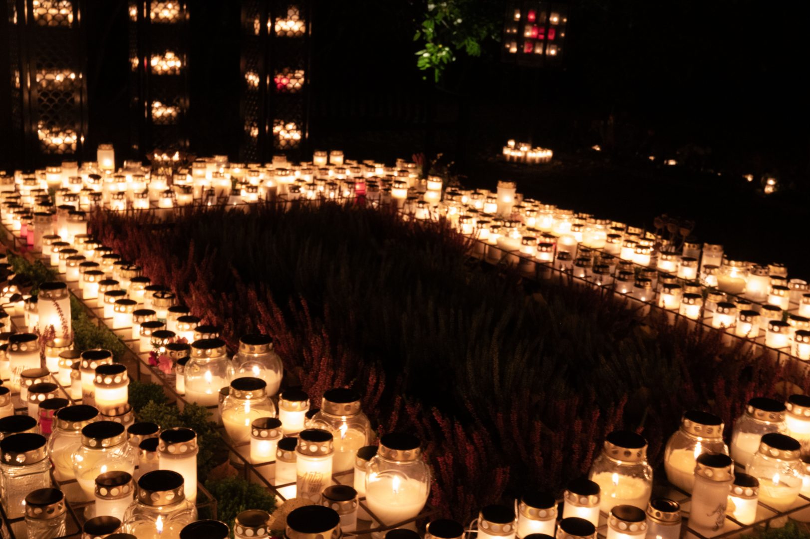 Minneslunden på en av kyrkogårdarna i kalmar. I mitten syns någon röd växt och runtom hundratals tända ljus. Även i bakgrunden kan man skymta tända ljus.